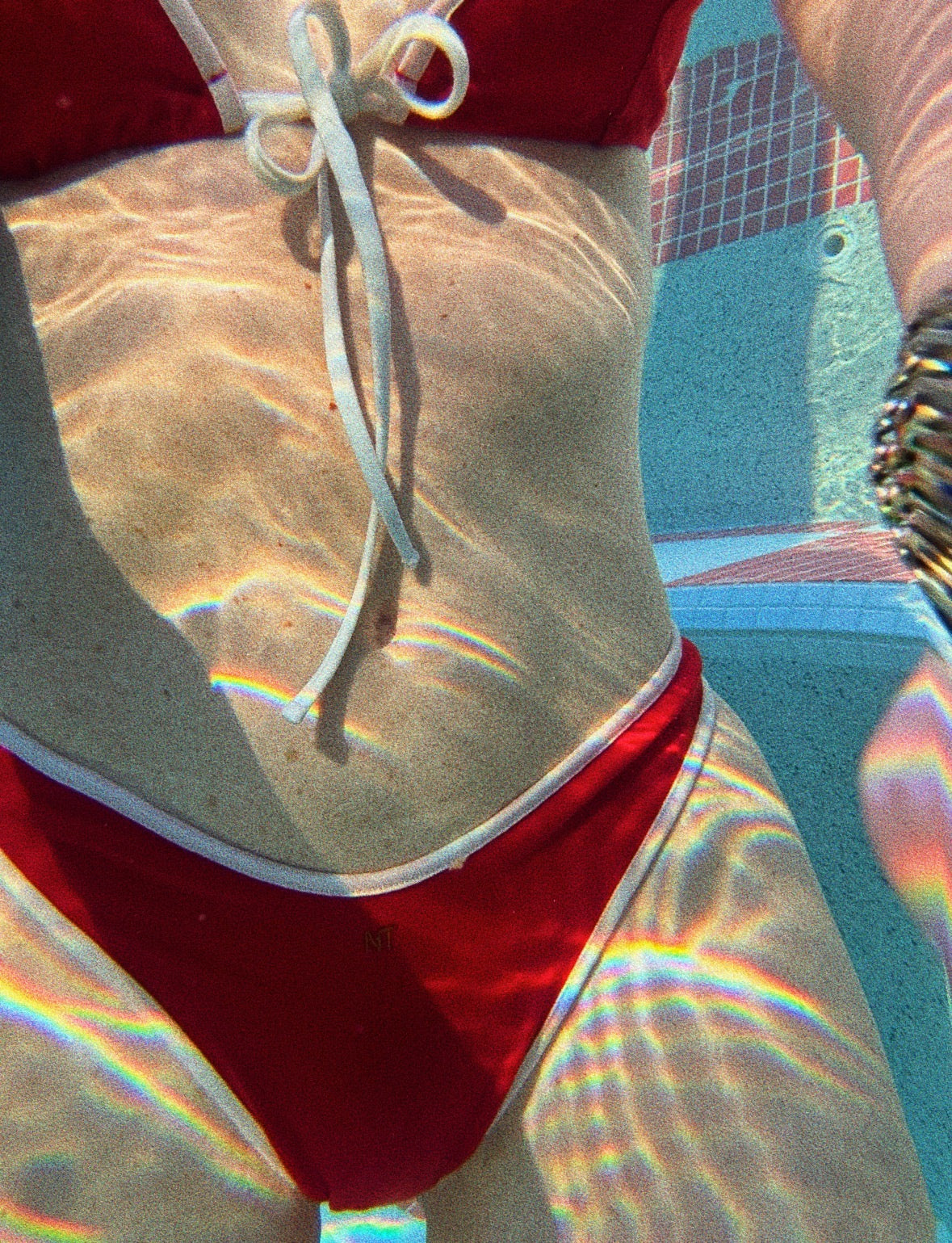 Red Bikini and underwater photo of the girl swimming in the natural fiber eco friendly bikini. Off white border and red body of the bikini tied in the front. 